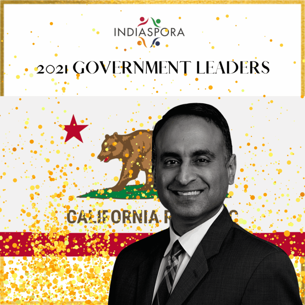 A man in suit and tie standing next to california flag.