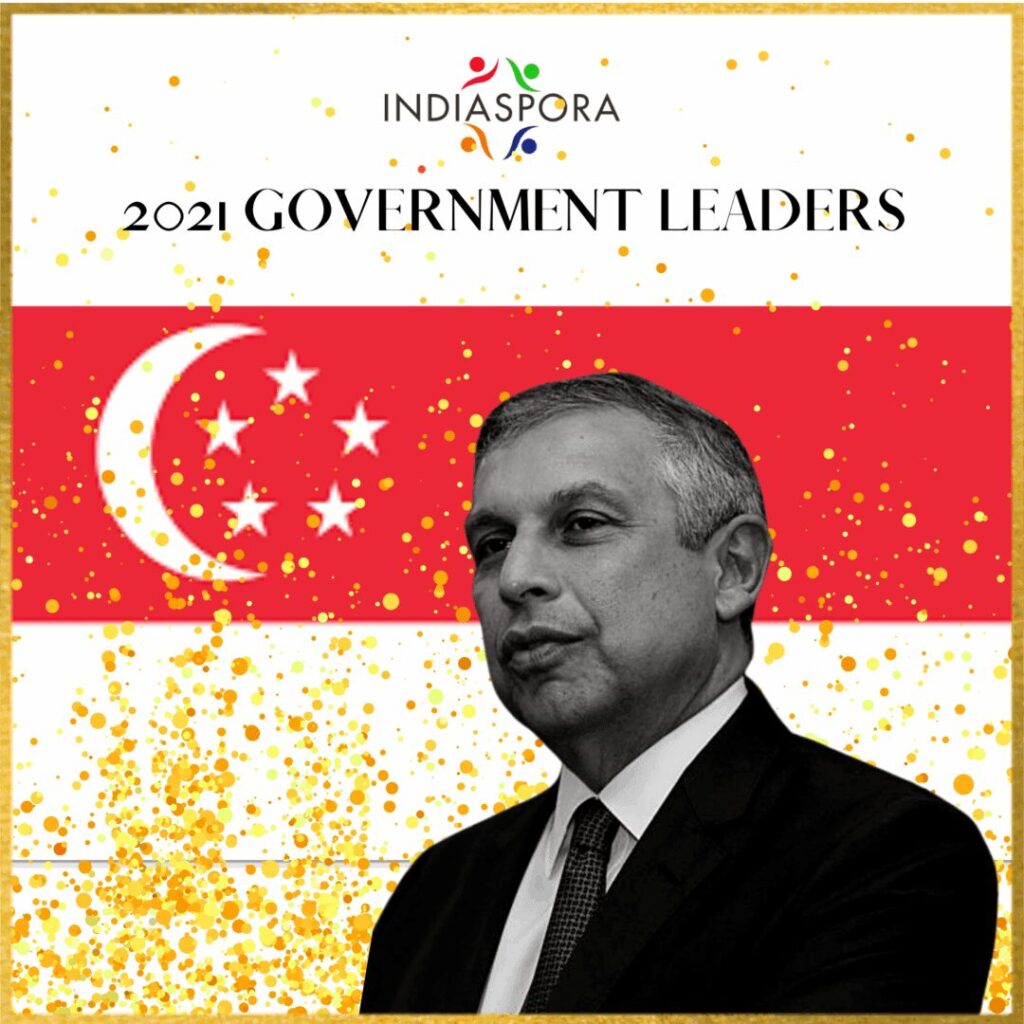 A man in suit and tie standing next to an asian flag.