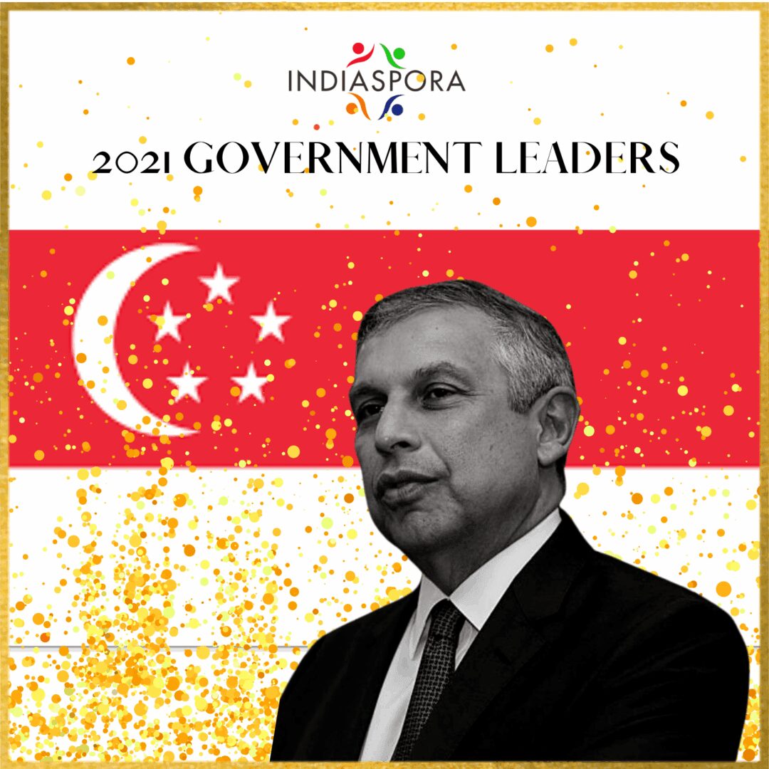 A man in suit and tie standing next to an asian flag.