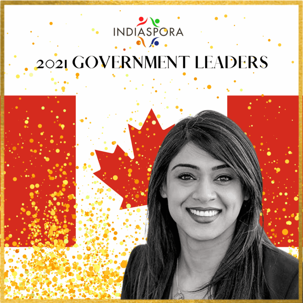 A woman standing in front of the canadian flag.