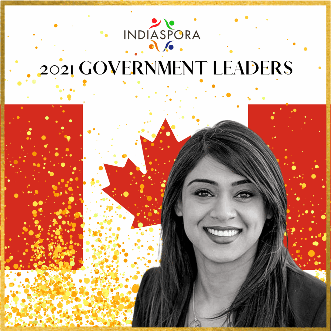 A woman standing in front of the canadian flag.