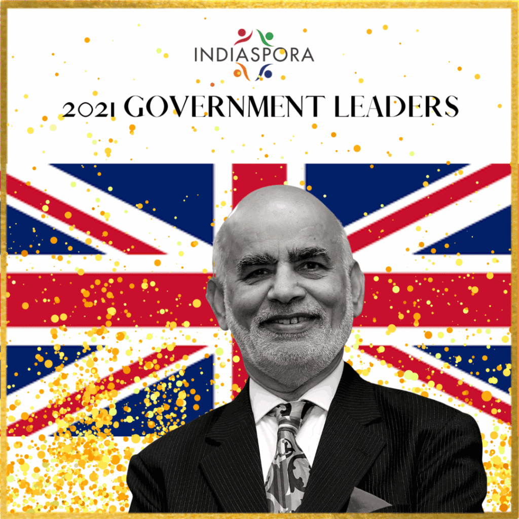 A man in suit and tie with the british flag behind him.