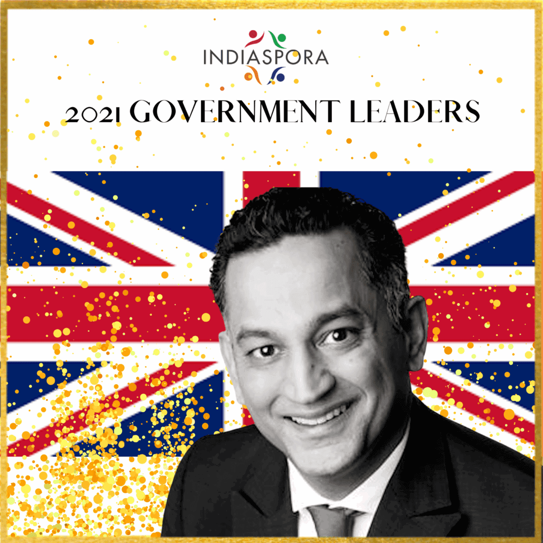 A man in suit and tie with the british flag behind him.