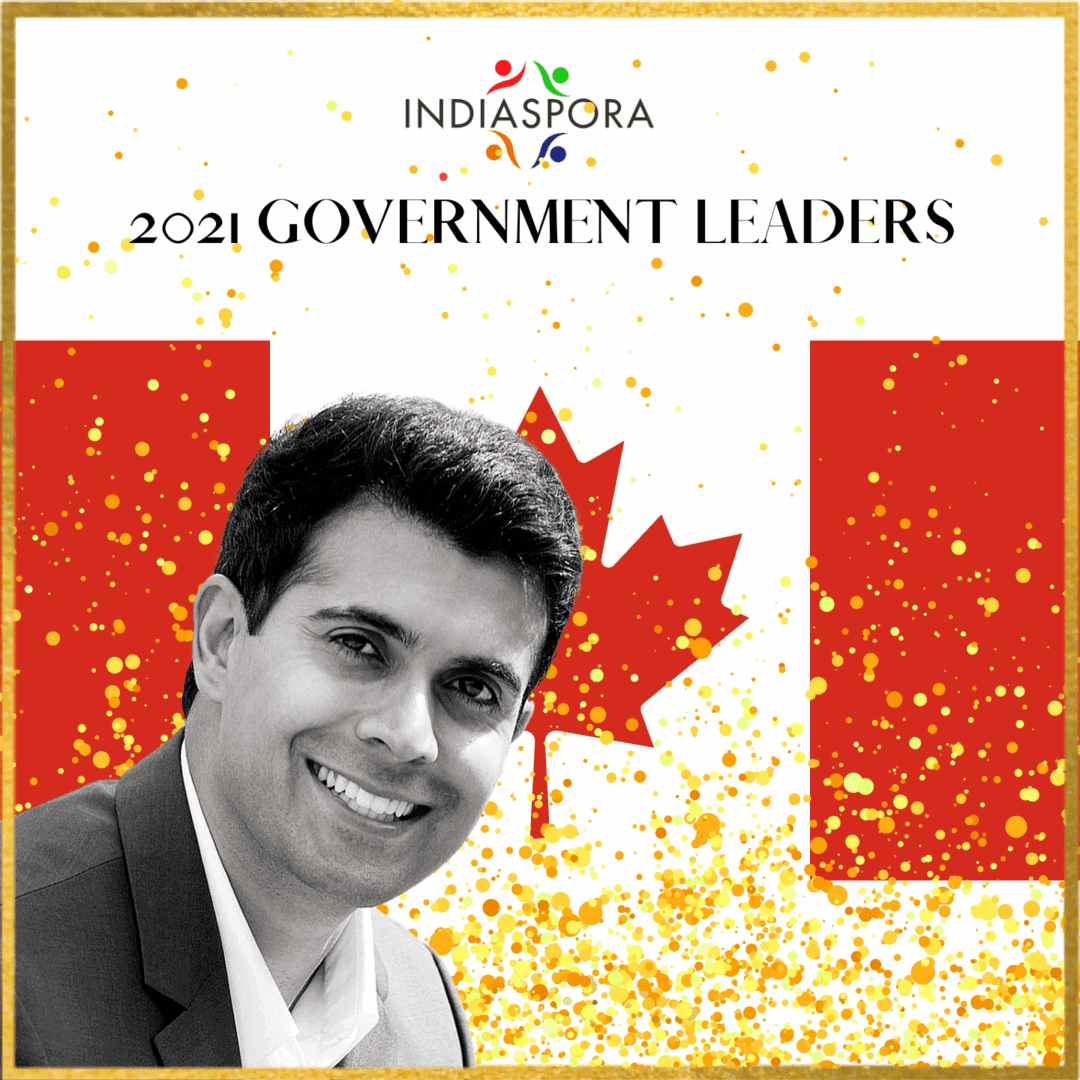 A man in a suit and tie next to the canadian flag.