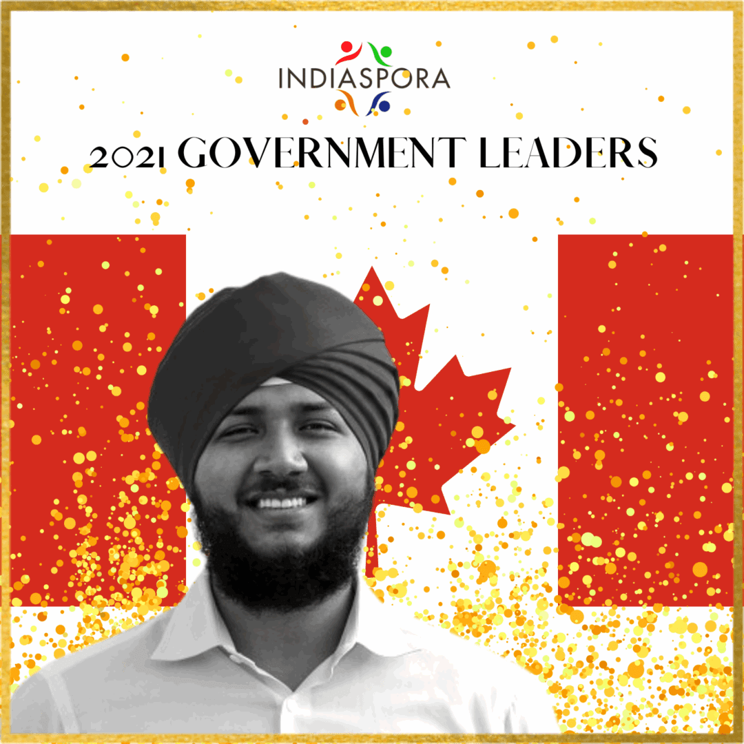 A man with a turban is standing in front of the canadian flag.
