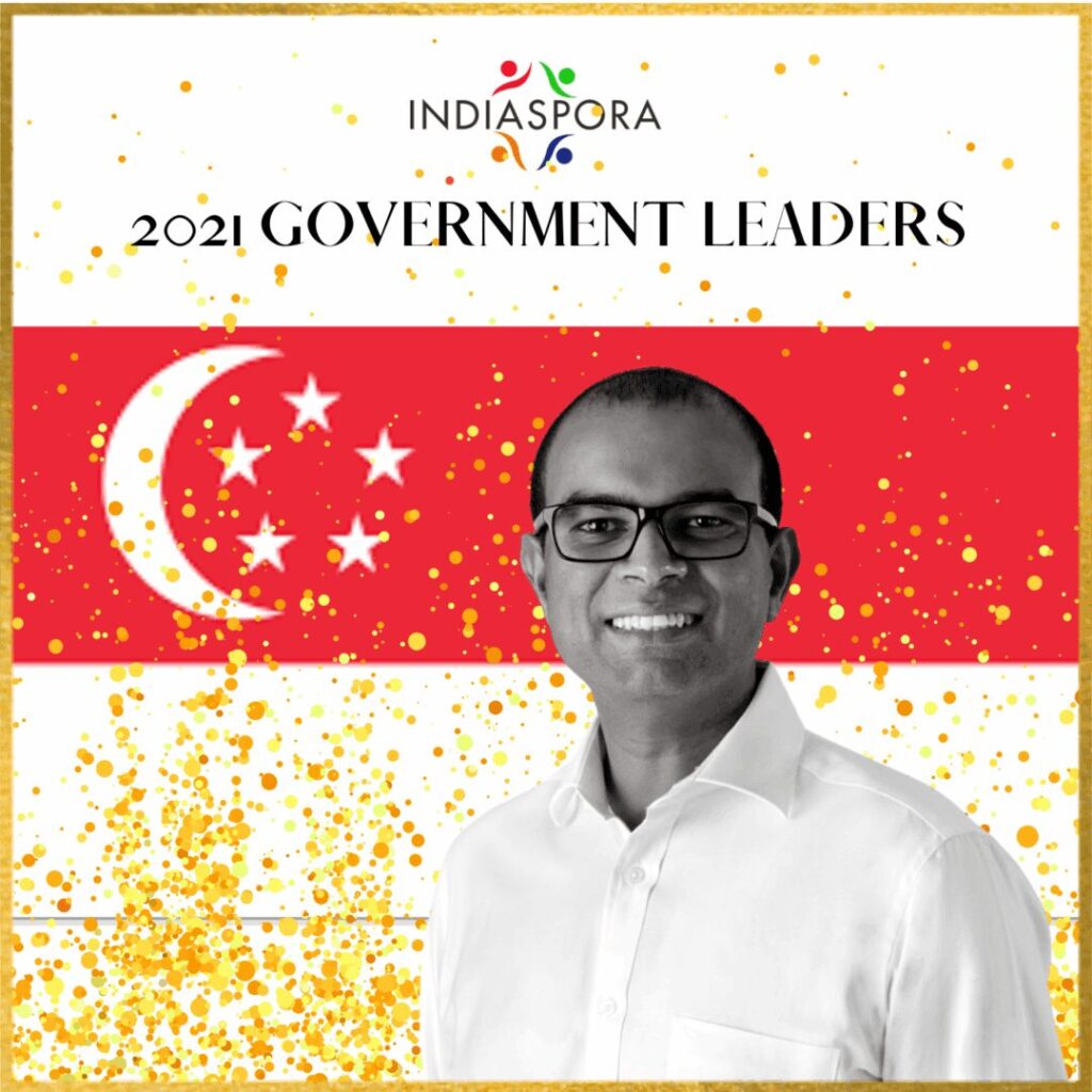 A man standing in front of the singapore flag.