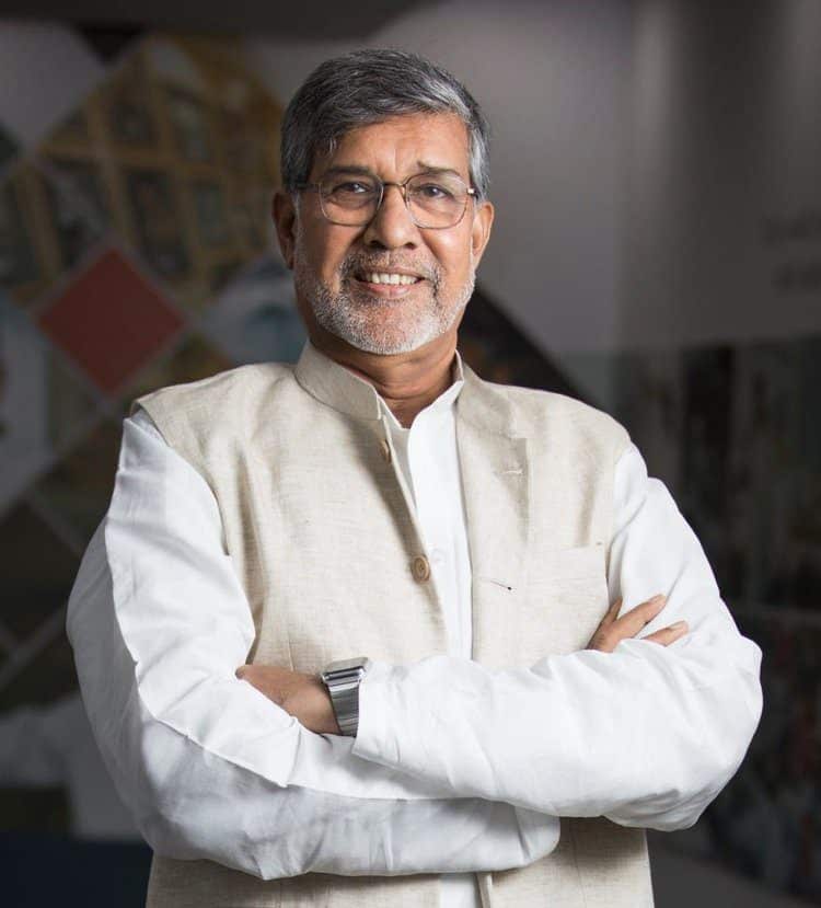 A man with his arms crossed wearing a white shirt.