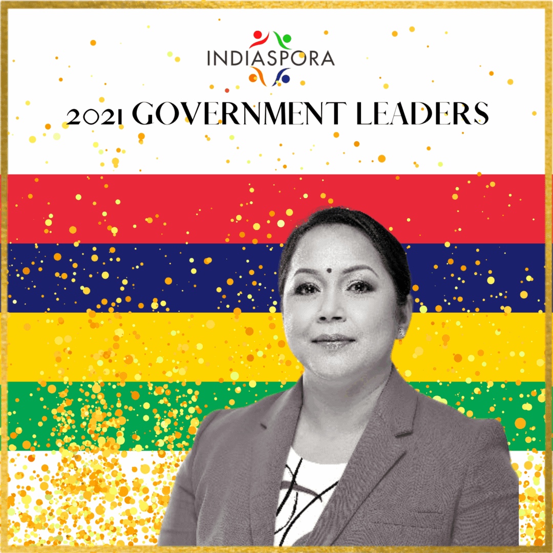 A woman standing in front of the flag of india.