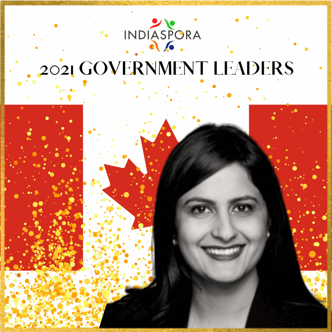 A woman standing in front of the canadian flag.
