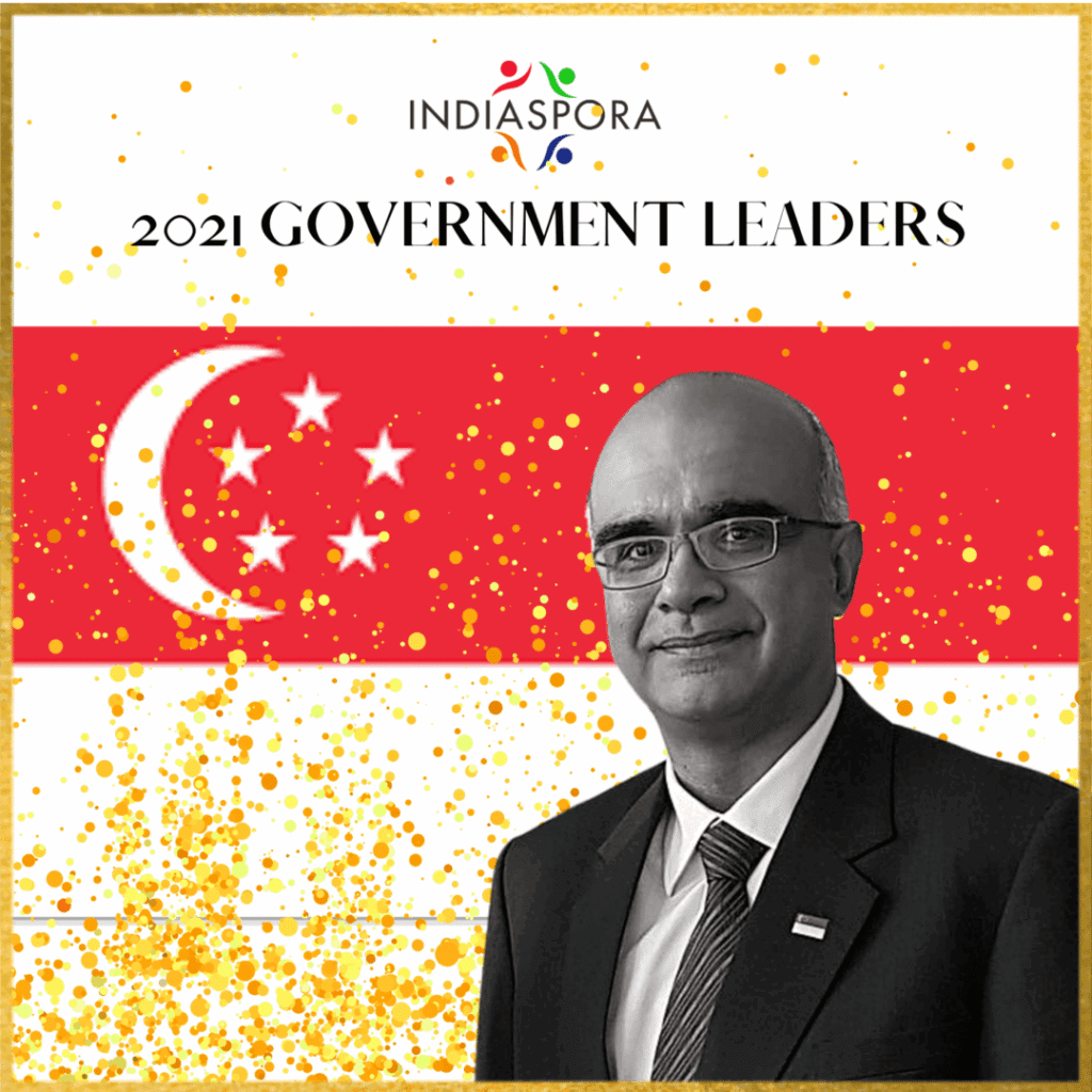 A man in suit and tie standing next to an asian flag.