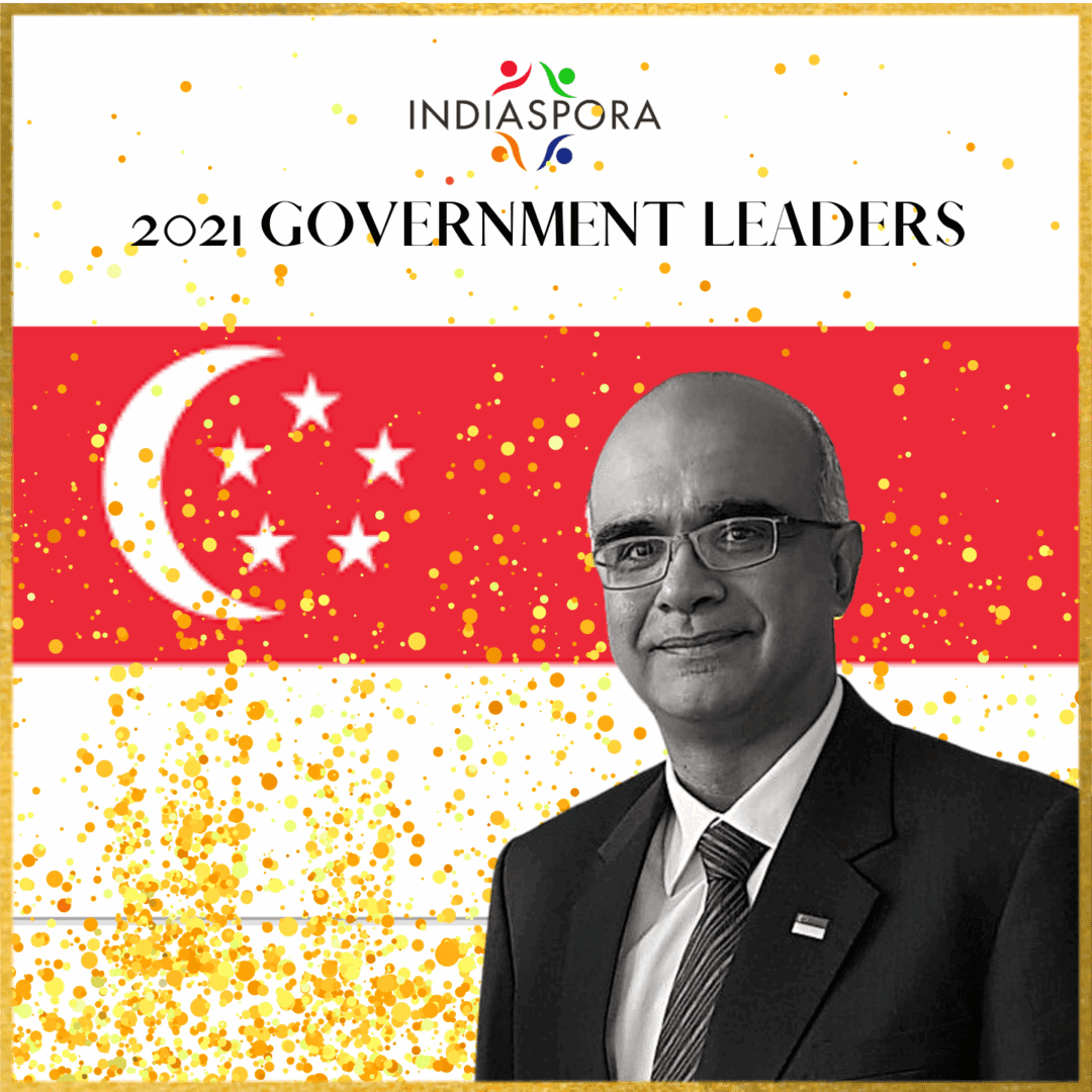 A man in suit and tie standing next to an asian flag.