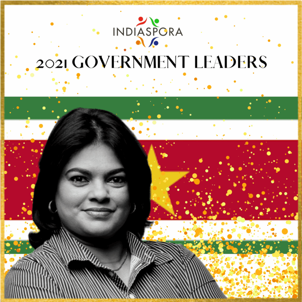 A woman standing in front of an image with the word indiaspora written underneath her.