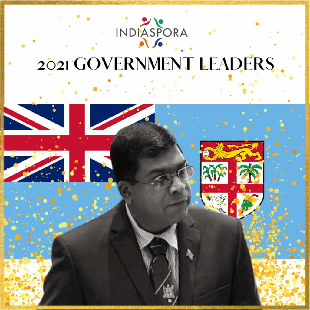 A man in front of the flag of fiji.