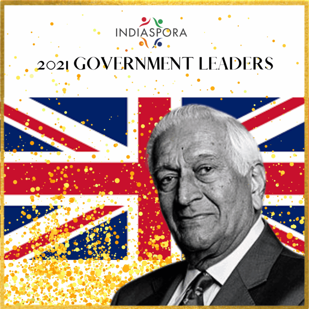 A man in suit and tie with the british flag behind him.