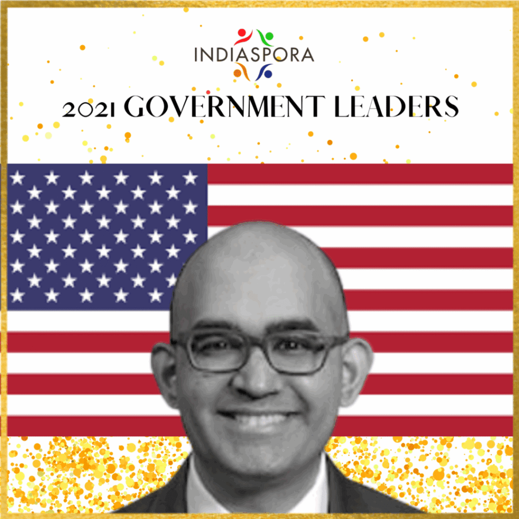 A man with glasses and an american flag background