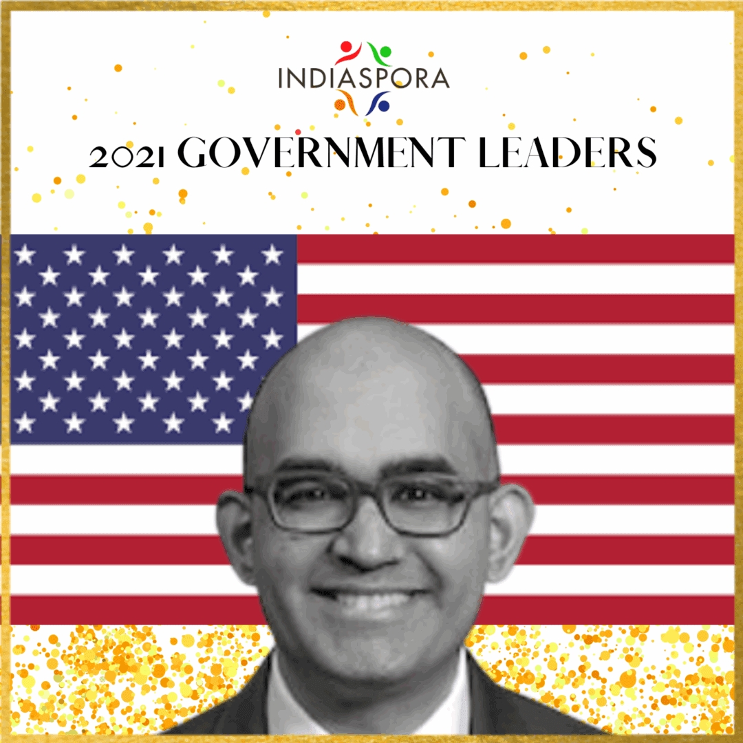 A man with glasses and an american flag background