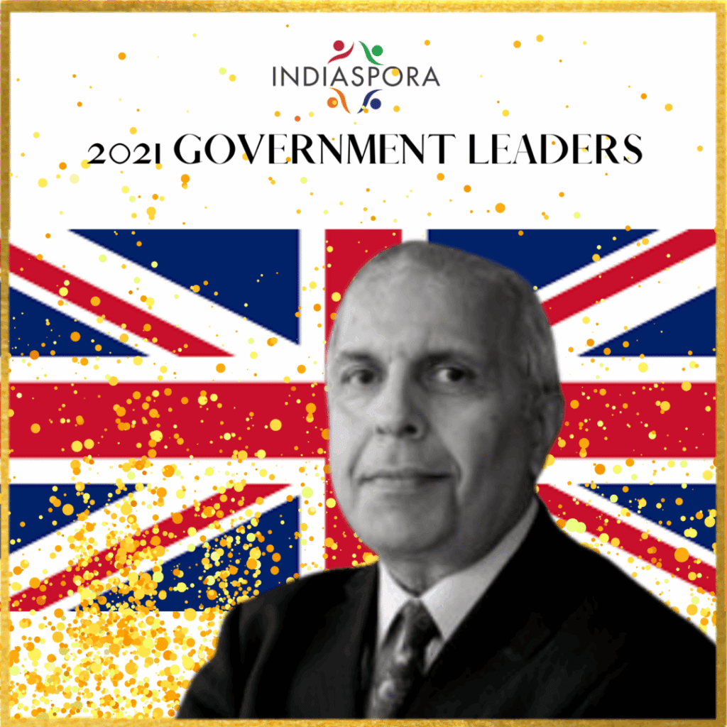 A man in suit and tie with the british flag behind him.