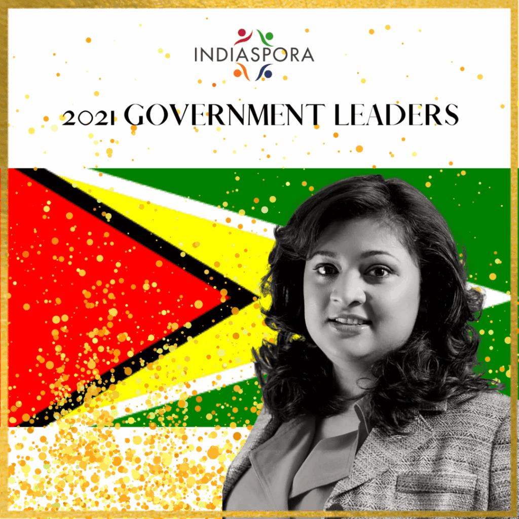 A woman standing in front of the flag of guyana.