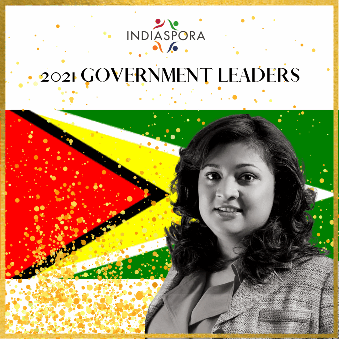 A woman standing in front of the flag of guyana.