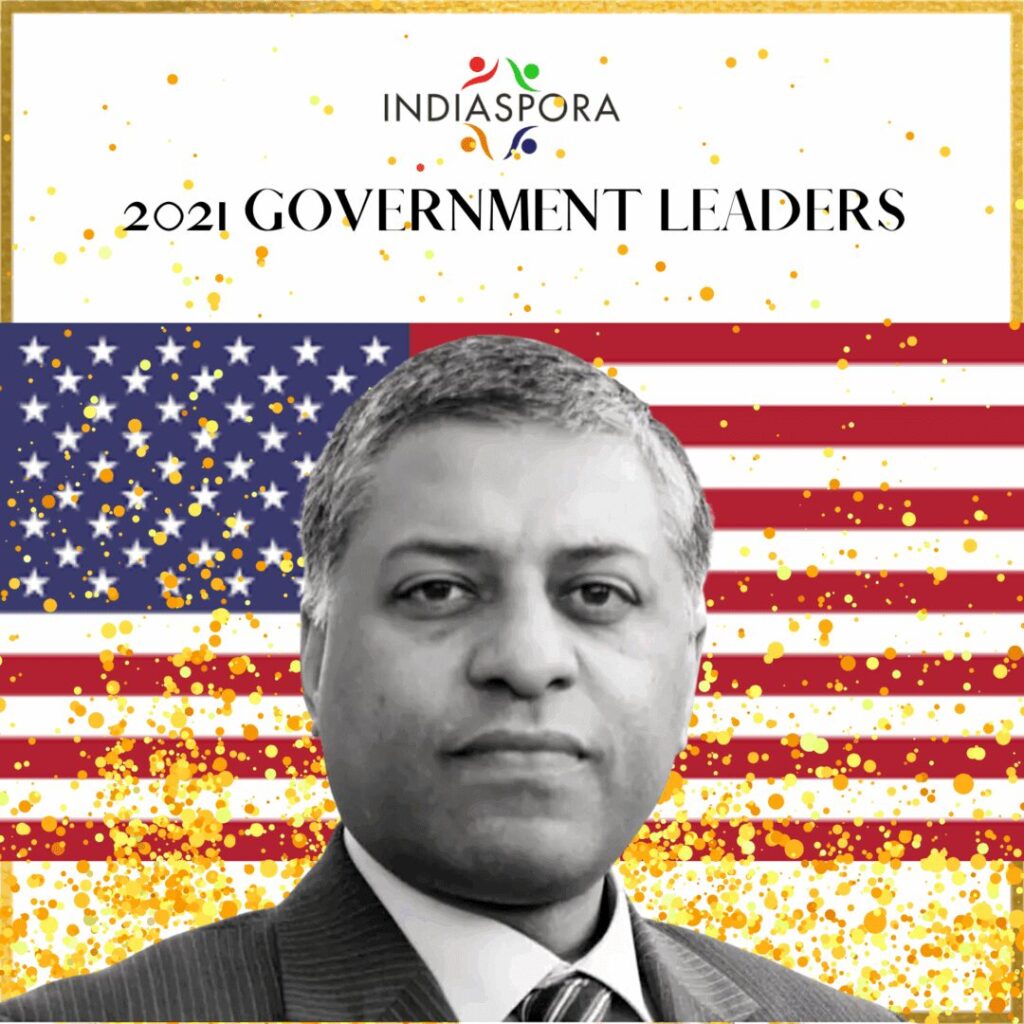 A man in suit and tie with american flag background.