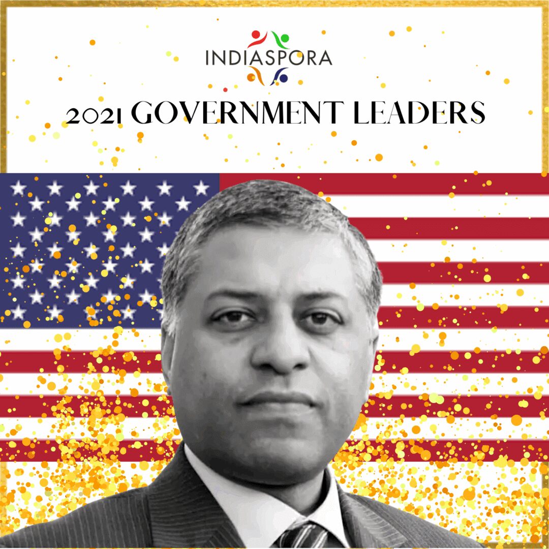 A man in suit and tie with american flag background.