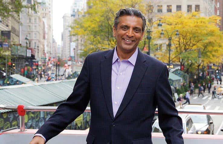 A man in a suit standing on the street.
