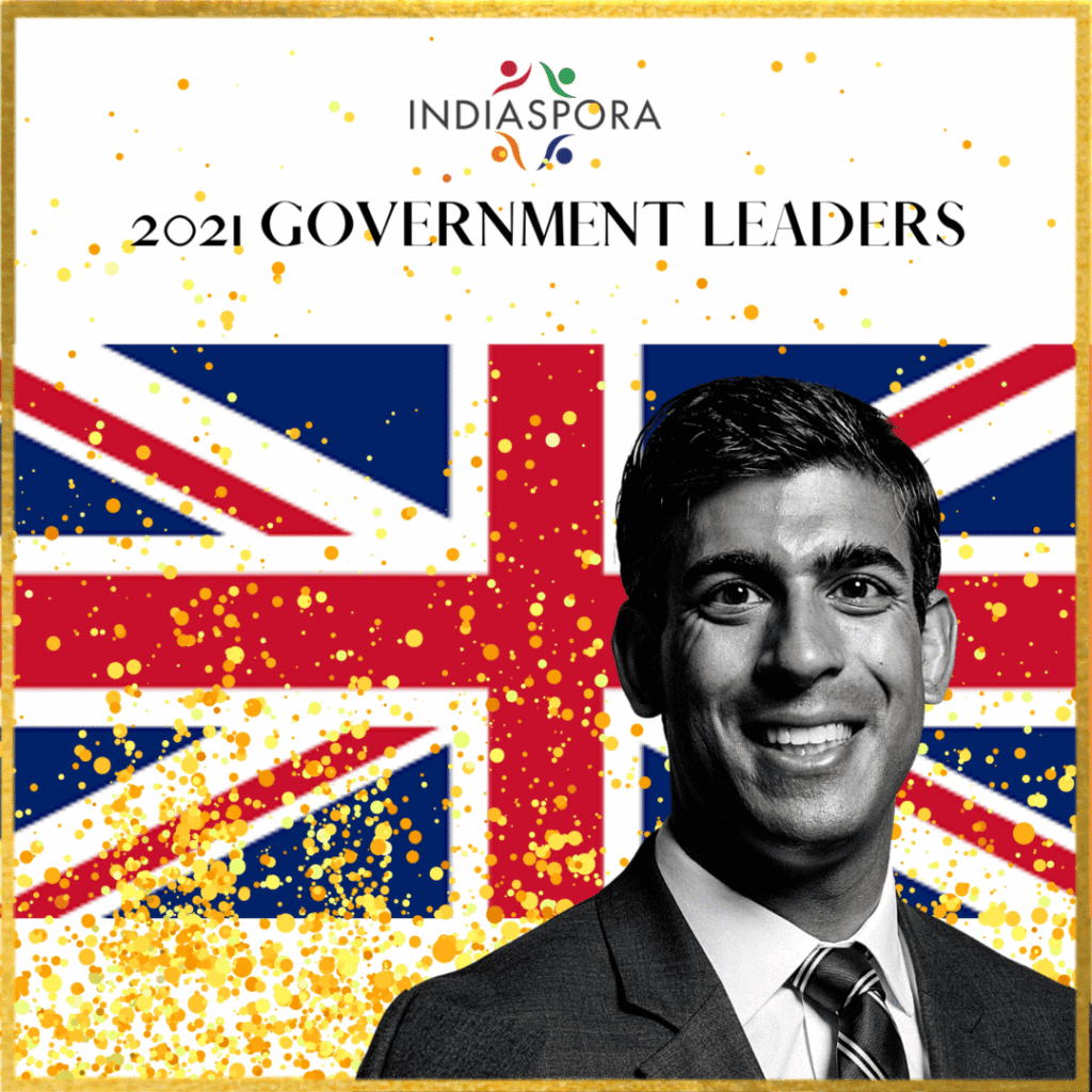 A man in suit and tie with the british flag behind him.
