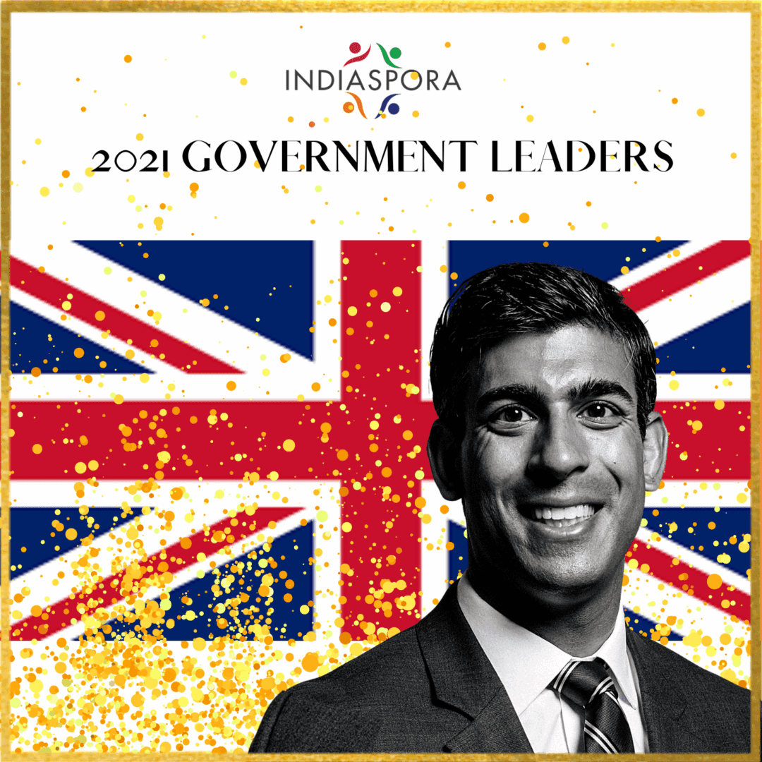 A man in suit and tie with the british flag behind him.