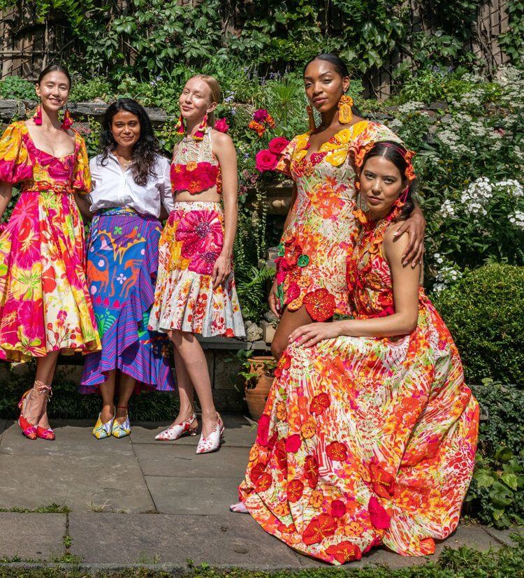 A group of women in colorful dresses posing for the camera.