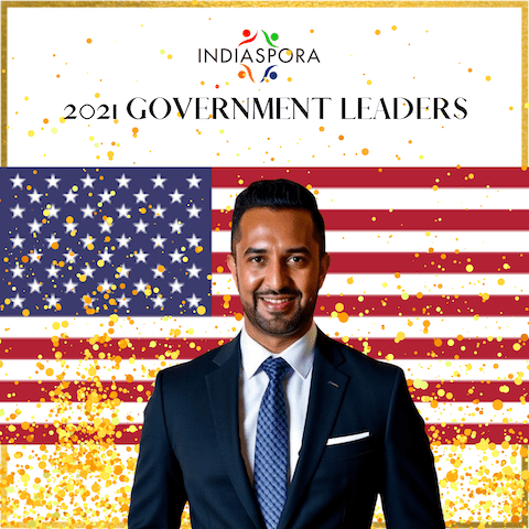 Man in suit with American flag background.