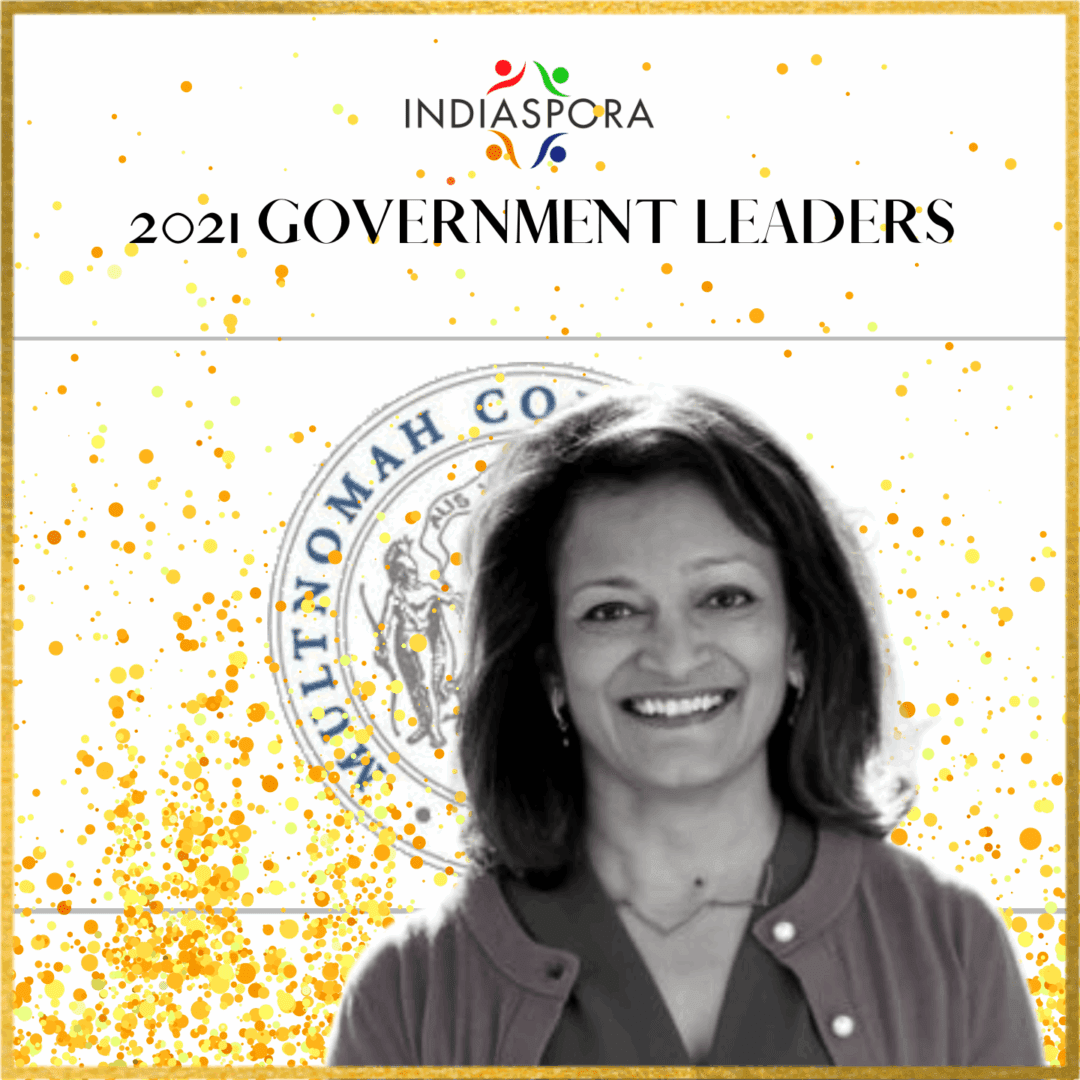A woman standing in front of the government leaders logo.