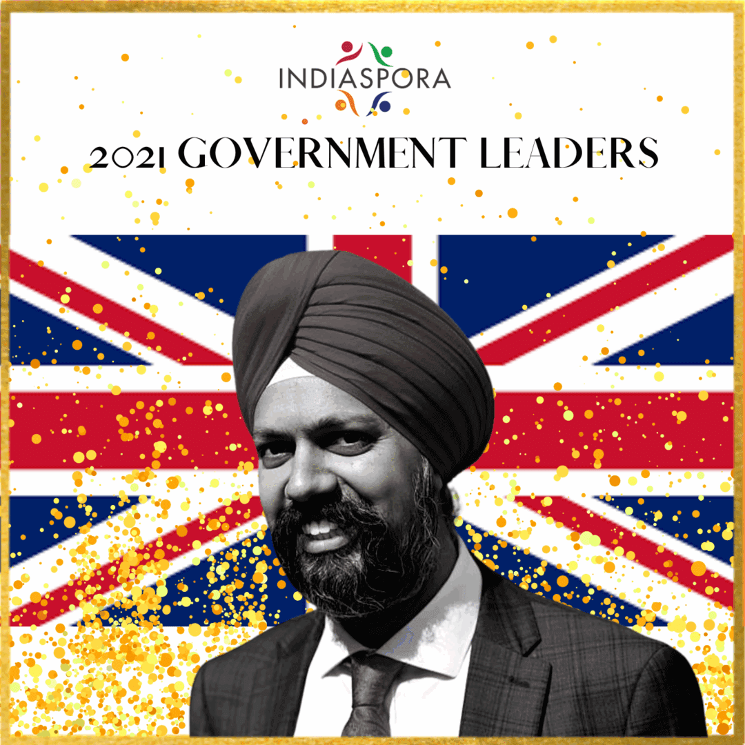 A man with a turban and suit on in front of the british flag.