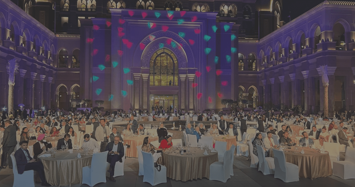 A painting of people sitting at tables in front of a building.