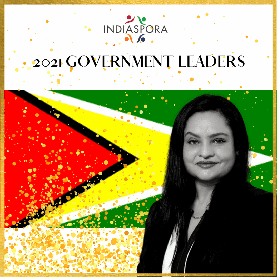 A woman standing in front of the flag of guyana.