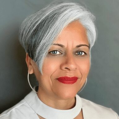 A woman with white hair and red lipstick.