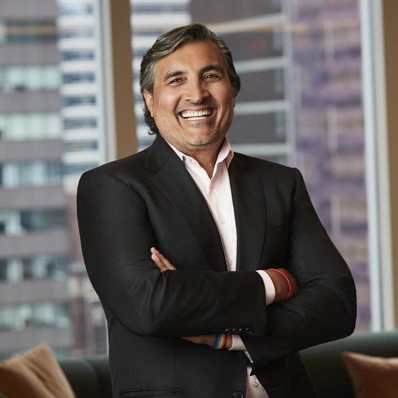 A man in a suit and tie smiling for the camera.
